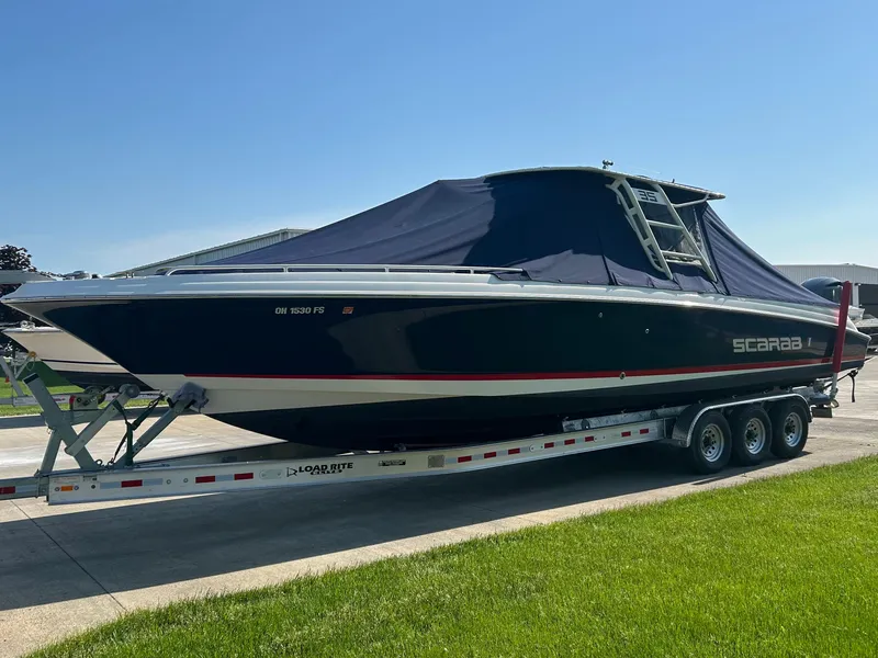 Slide: The Image of 2015 Wellcraft 35 Scarab boat on trailer, covered, parked on driveway. - 2