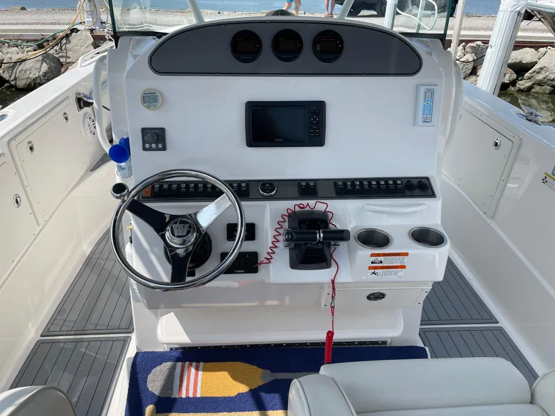 Slide: The Image of 2015 Wellcraft 35 Scarab boat helm with steering wheel, controls, and navigation display. - 23