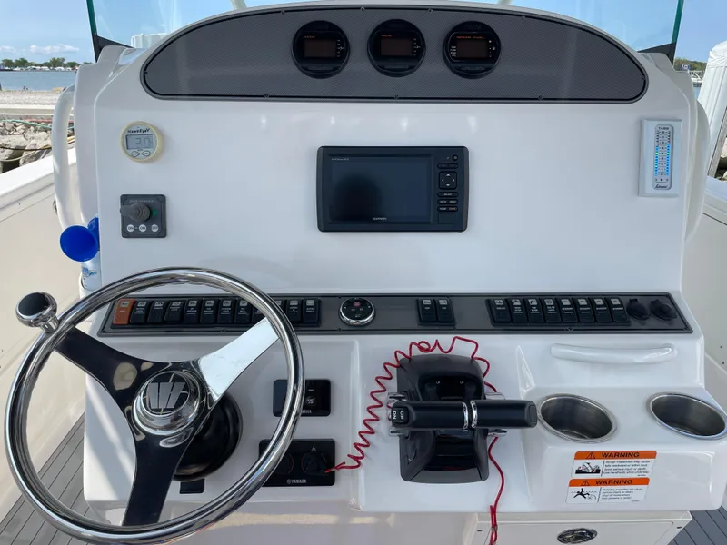 Slide: The Image of Control panel of a 2015 Wellcraft 35 Scarab boat with steering wheel and gauges. - 24