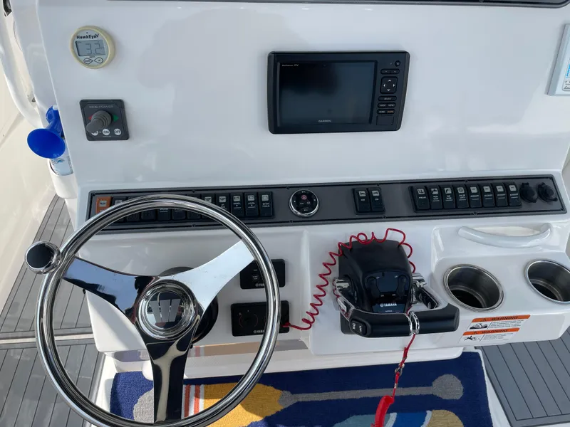 Slide: The Image of Control panel of a 2015 Wellcraft 35 Scarab boat with steering wheel and navigation equipment. - 28