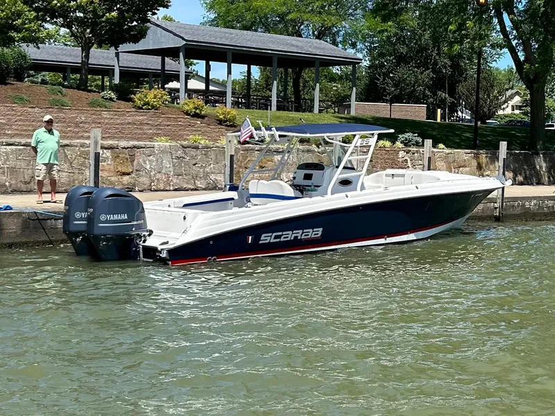 Slide: The Image of 2015 Wellcraft 35 Scarab boat docked with twin Yamaha engines, scenic waterfront background. - 3