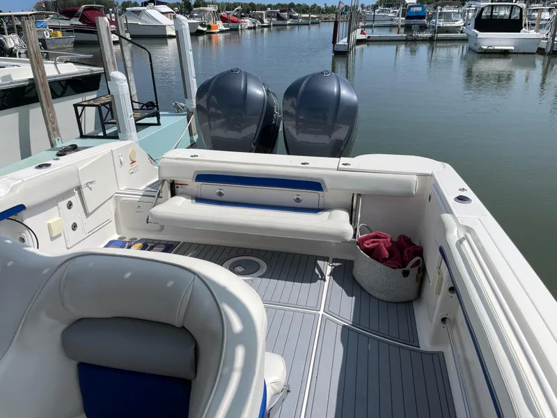 Slide: The Image of 2015 Wellcraft 35 Scarab boat interior at marina, featuring seating and twin engines. - 30