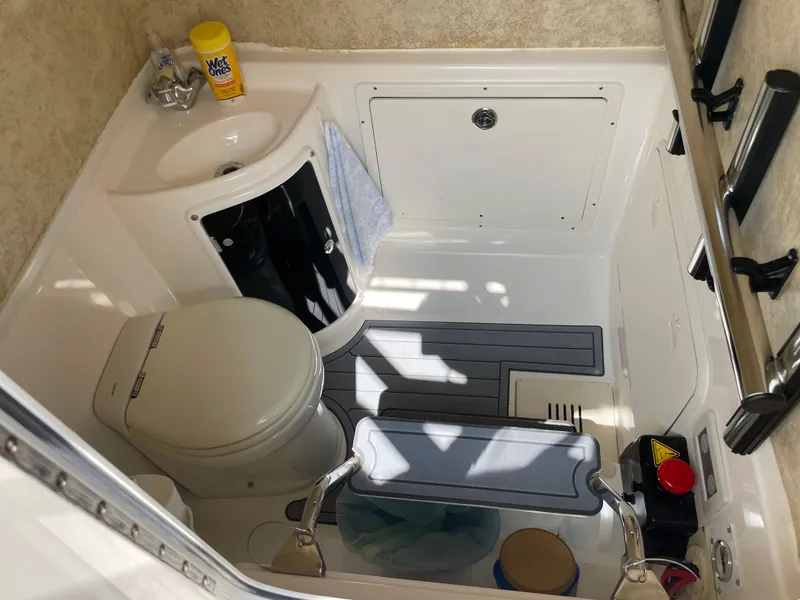 Slide: The Image of Interior of 2015 Wellcraft 35 Scarab boat bathroom with toilet, sink, and cleaning supplies. - 36