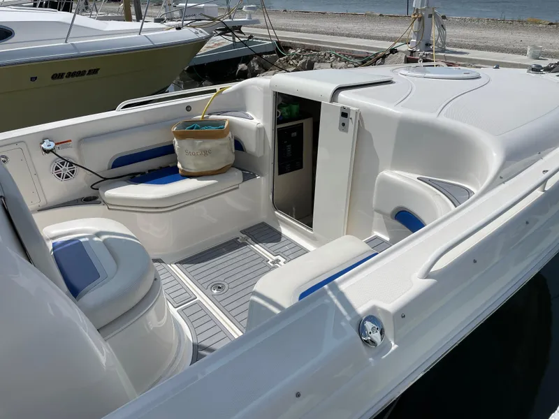 Slide: The Image of 2015 Wellcraft 35 Scarab boat interior with seating and storage, docked by the water. - 9