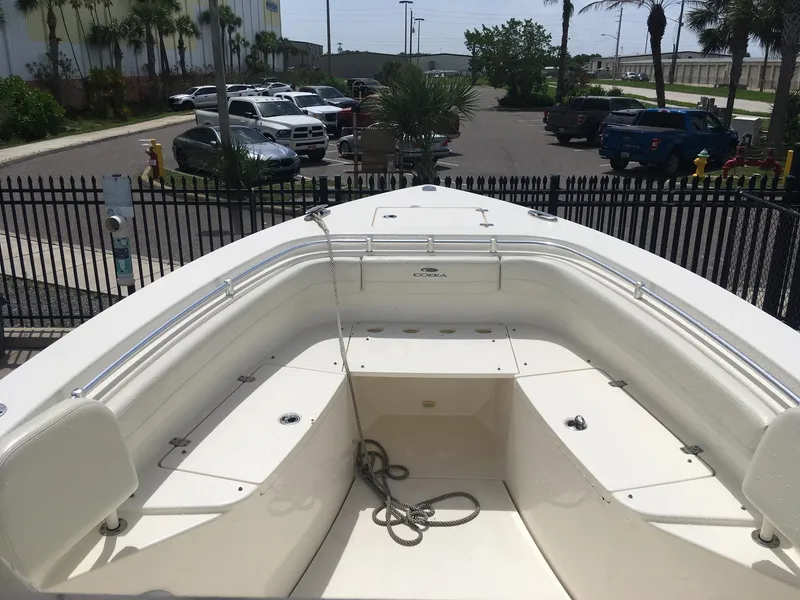 Slide: The Image of 2017 Cobia 296 CC boat with spacious seating and sleek design in a parking area. - 10