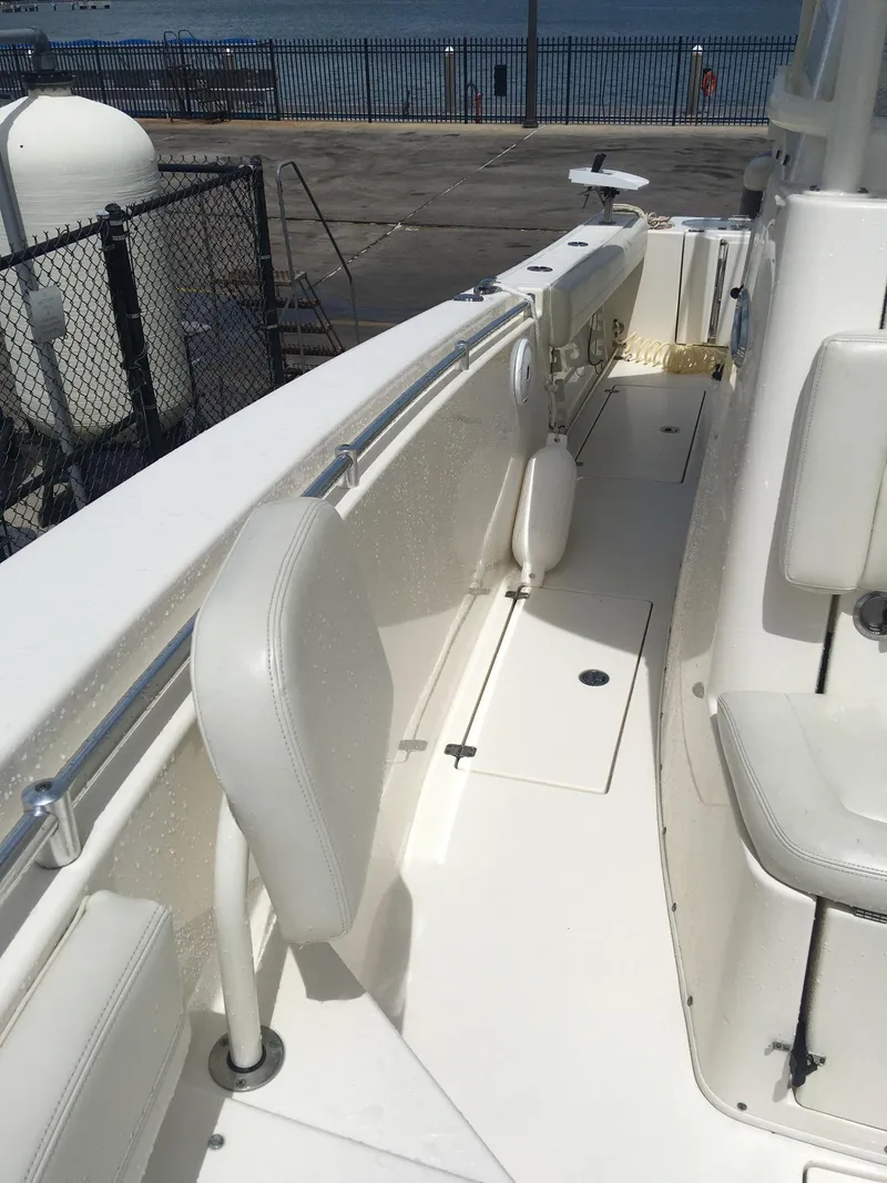 Slide: The Image of 2017 Cobia 296 CC boat deck with white seating and railing. - 11