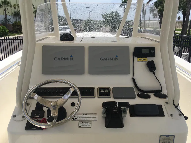 Slide: The Image of 2017 Cobia 296 CC boat dashboard with Garmin navigation displays and steering wheel. - 19
