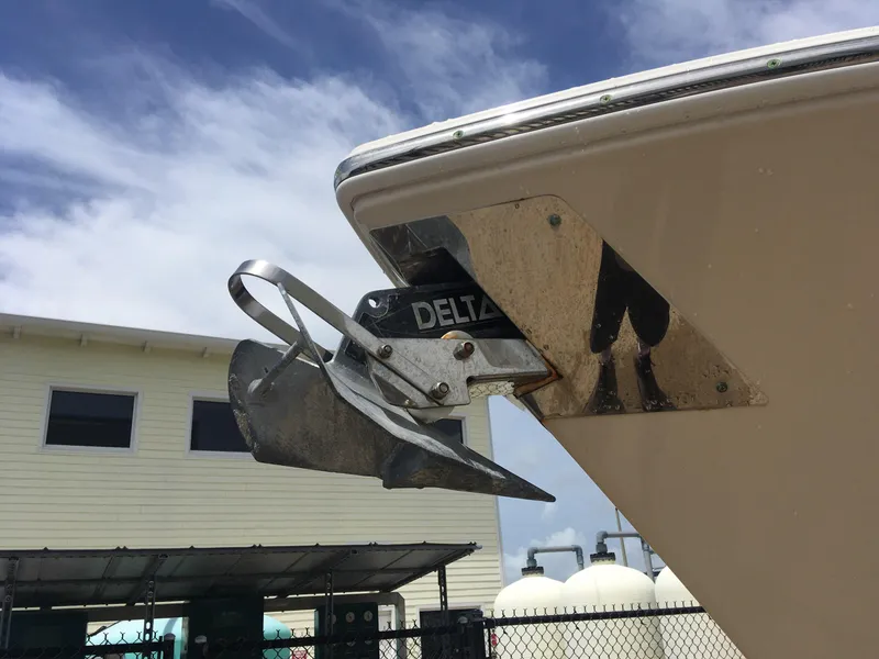 Slide: The Image of 2017 Cobia 296 CC boat with Delta anchor, docked near a building under a blue sky. - 2