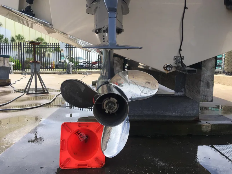 Slide: The Image of 2017 Cobia 296 CC boat propeller and engine detail in a maintenance area. - 21