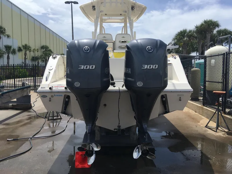 Slide: The Image of 2017 Cobia 296 CC boat with twin Yamaha 300 engines, docked outdoors. - 24