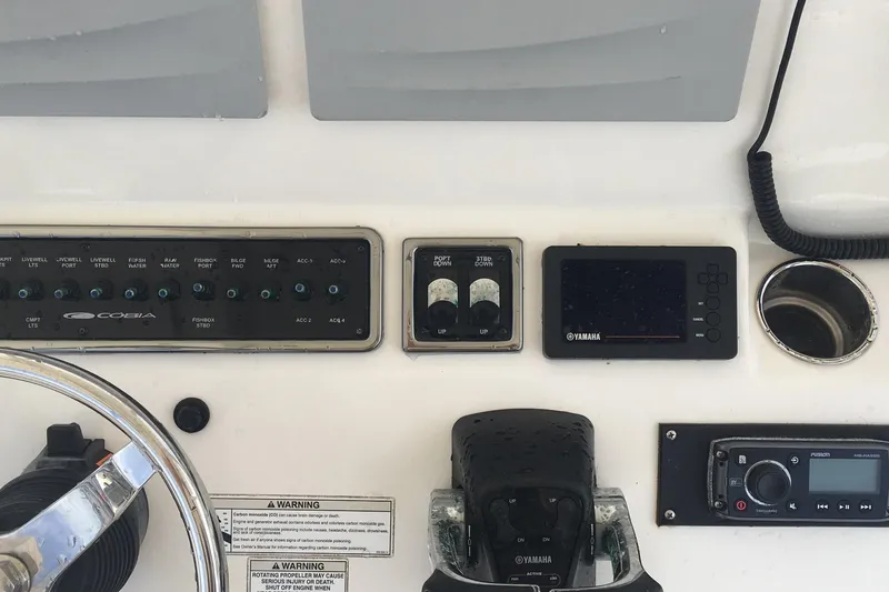 Slide: The Image of 2017 Cobia 296 CC boat dashboard with controls and navigation equipment. - 25