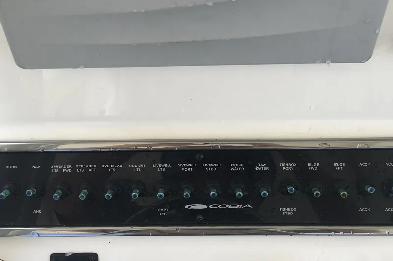 Slide: The Image of Control panel of a 2017 Cobia 296 CC boat with labeled switches. - 26