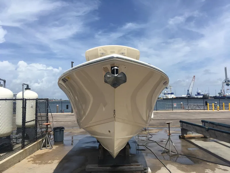 Slide: The Image of 2017 Cobia 296 CC boat on dock, clear sky background. - 3