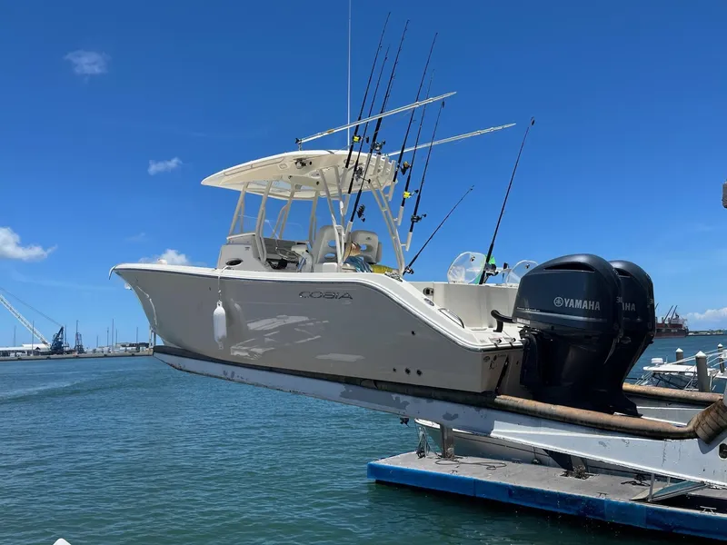 Slide: The Image of 2017 Cobia 296 CC boat with Yamaha engines docked at marina. - 4