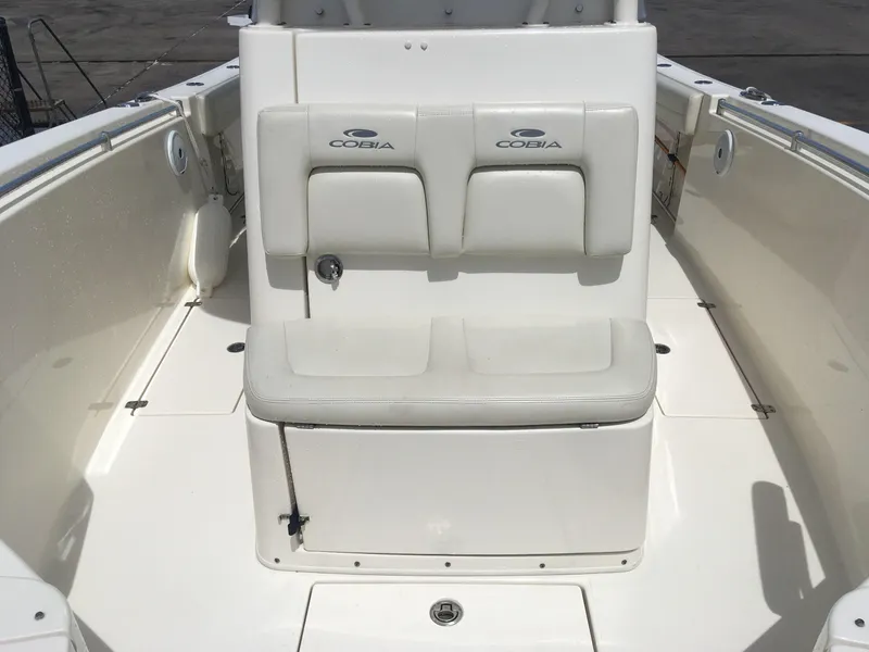 Slide: The Image of 2017 Cobia 296 CC boat interior with cushioned seating and clean white deck. - 8