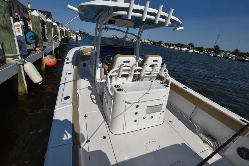 Slide: The Image of 2016 Sportsman Open 312 Center Console boat docked by the water. - 13