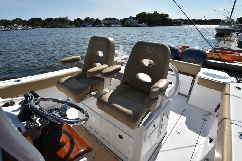 Slide: The Image of 2016 Sportsman Open 312 Center Console boat interior with dual seats on a sunny day. - 15