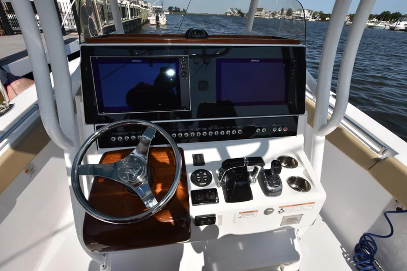 Slide: The Image of 2016 Sportsman Open 312 Center Console boat dashboard with dual screens and steering wheel. - 16