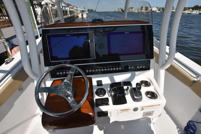 Slide: The Image of 2016 Sportsman Open 312 Center Console boat dashboard with dual screens and steering wheel. - 19