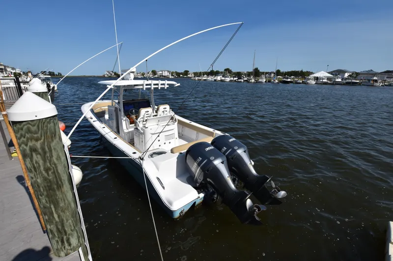Slide: The Image of 2016 Sportsman Open 312 Center Console boat docked in a marina with twin engines. - 2