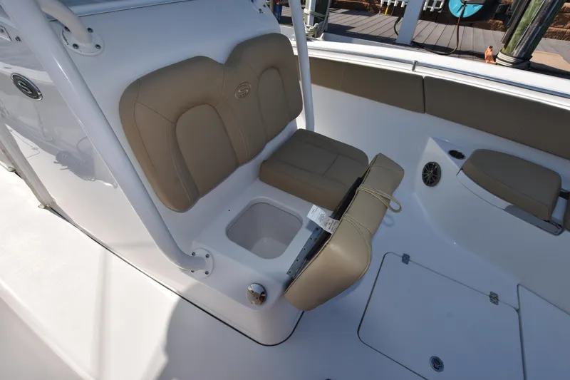 Slide: The Image of 2016 Sportsman Open 312 Center Console boat interior with beige seating and storage compartment. - 28