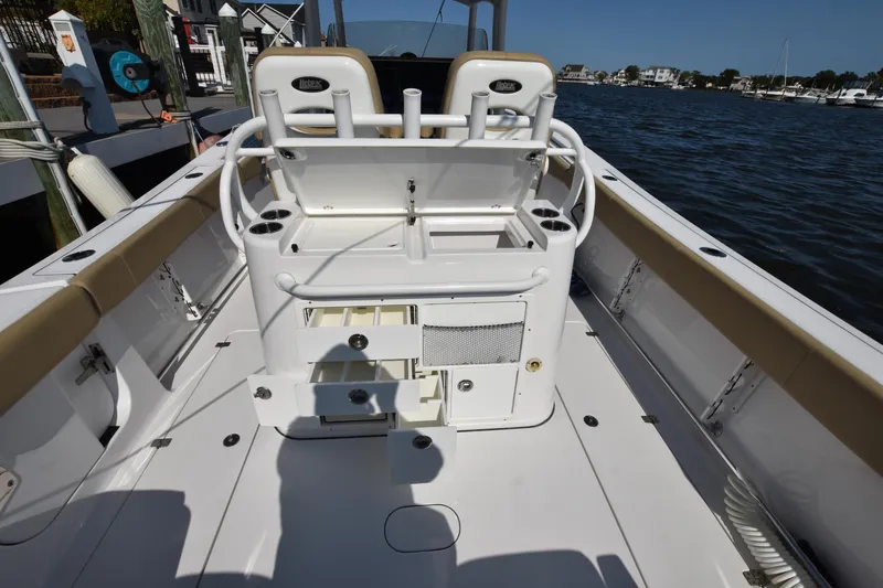 Slide: The Image of 2016 Sportsman Open 312 Center Console boat interior with storage and seating by the water. - 4