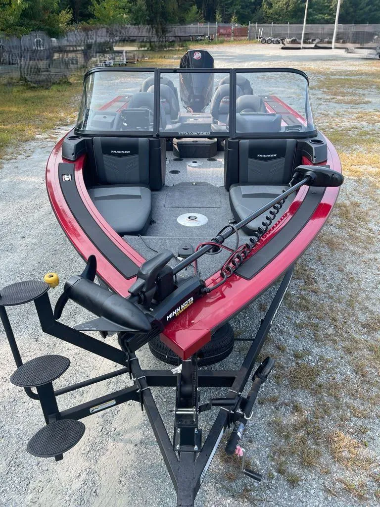 Slide: The Image of 2024 Tracker Targa V-19 Combo boat on trailer, red exterior, parked outdoors. - 3