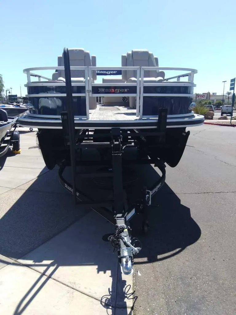 Slide: The Image of 2024 Ranger Reata 223F boat on trailer, front view in outdoor setting. - 2