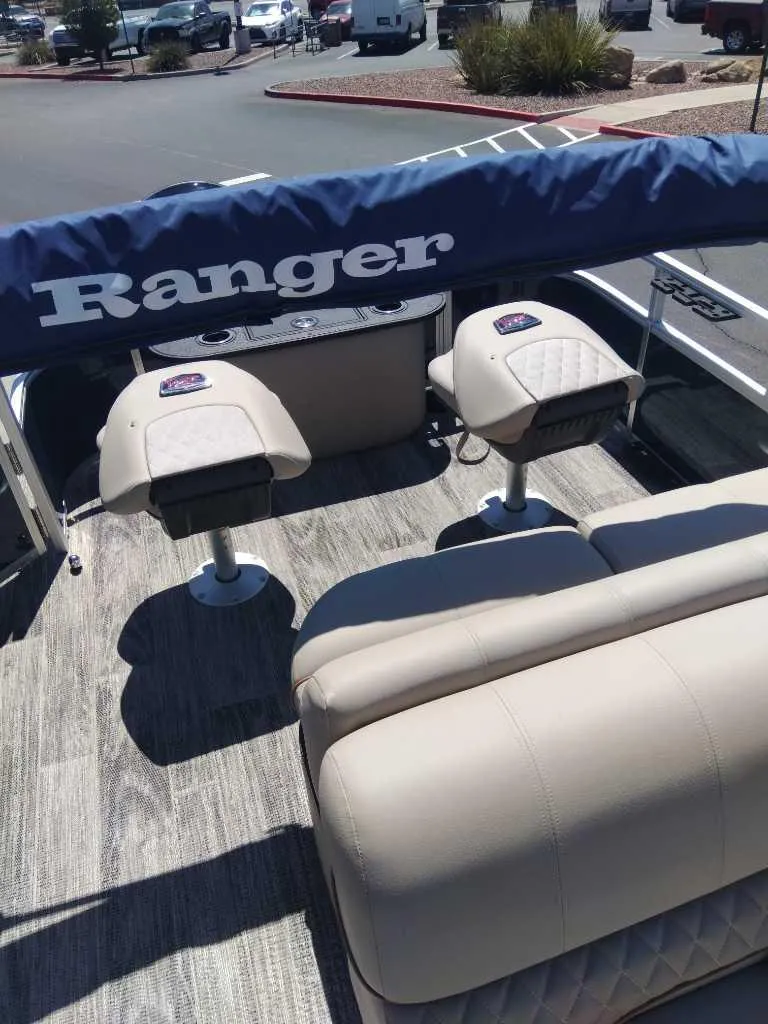 Slide: The Image of 2024 Ranger Reata 223F boat interior with cushioned seating and wood-style flooring. - 3