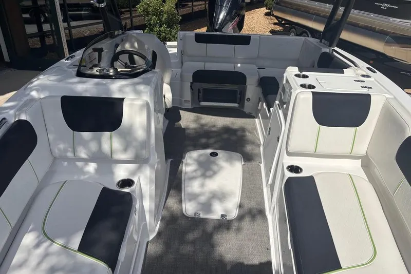 Slide: The Image of 2024 Tahoe 1950 boat interior with white and black seating, cup holders, and steering wheel. - 4