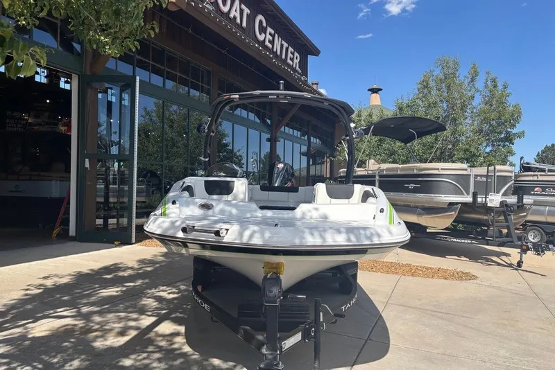 Slide: The Image of 2024 Tahoe 1950 boat displayed outside a boat center under a clear blue sky. - 2