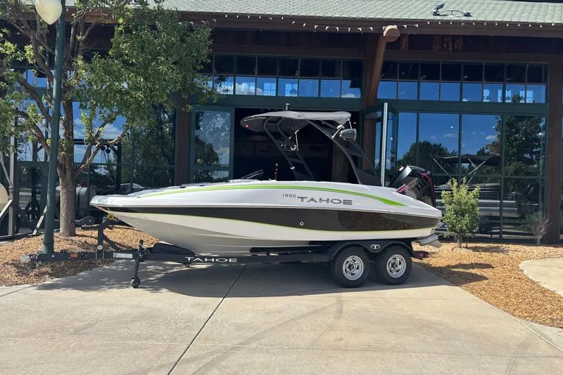 The Image of 2024 Tahoe 1950 boat on trailer, parked outside a building. - 0
