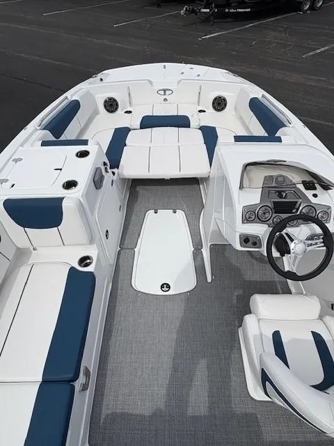 Slide: The Image of 2024 Tahoe 2150 boat interior with blue and white seating, steering console, and spacious layout. - 2