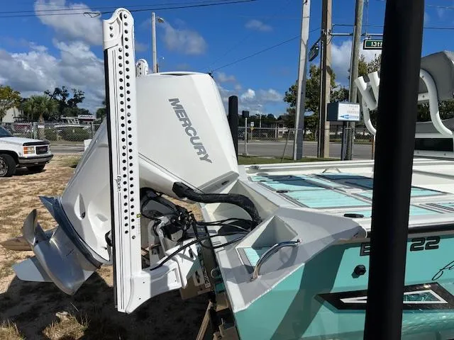 Slide: The Image of 2022 Lowe Bay 22 boat with Mercury engine, parked outdoors under a clear blue sky. - 3