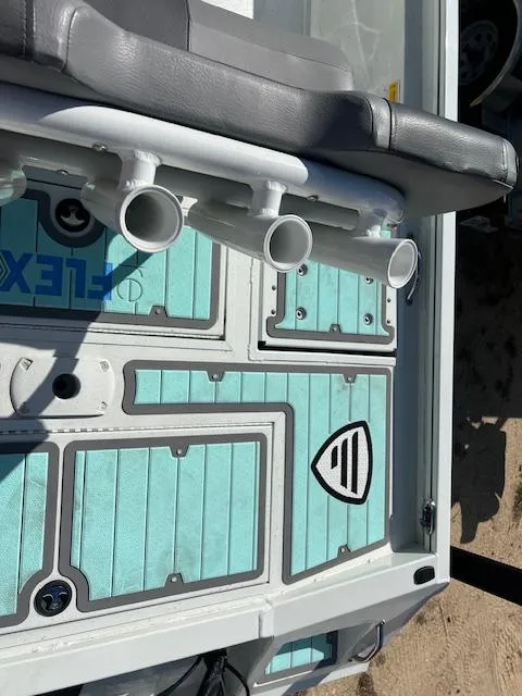 Slide: The Image of 2022 Lowe Bay 22 boat interior with teal flooring and rod holders. - 4