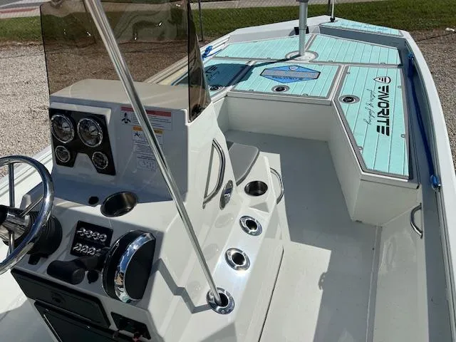 Slide: The Image of 2022 Lowe Bay 22 boat interior with steering console and turquoise deck. - 6