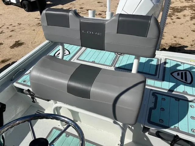 Slide: The Image of 2022 Lowe Bay 22 boat interior with gray seating and teal flooring. - 8