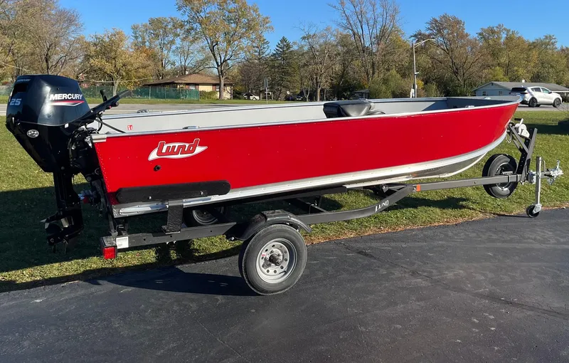 The Image of 2025 Lund 1600 Fury Tiller boat on trailer, red exterior, parked outdoors. - 0
