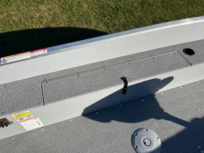 Slide: The Image of 2025 Lund 1600 Fury Tiller boat interior with storage compartment and textured flooring. - 13