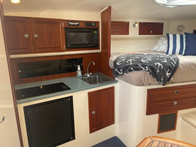 Slide: The Image of Interior of 2006 Carolina Classic 35 boat with kitchenette and cozy sleeping area. - 13