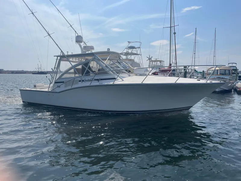 Slide: The Image of 2006 Carolina Classic 35 boat on water, clear sky, marina background. - 3