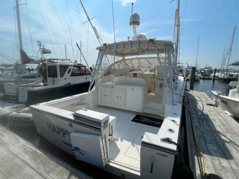 Slide: The Image of 2006 Carolina Classic 35 boat docked at marina, featuring spacious deck and fishing equipment. - 5