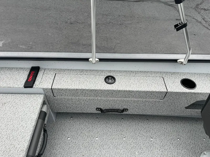 Slide: The Image of 2025 Lund 1775 Adventure Sport boat interior with storage compartment and cup holder. - 17