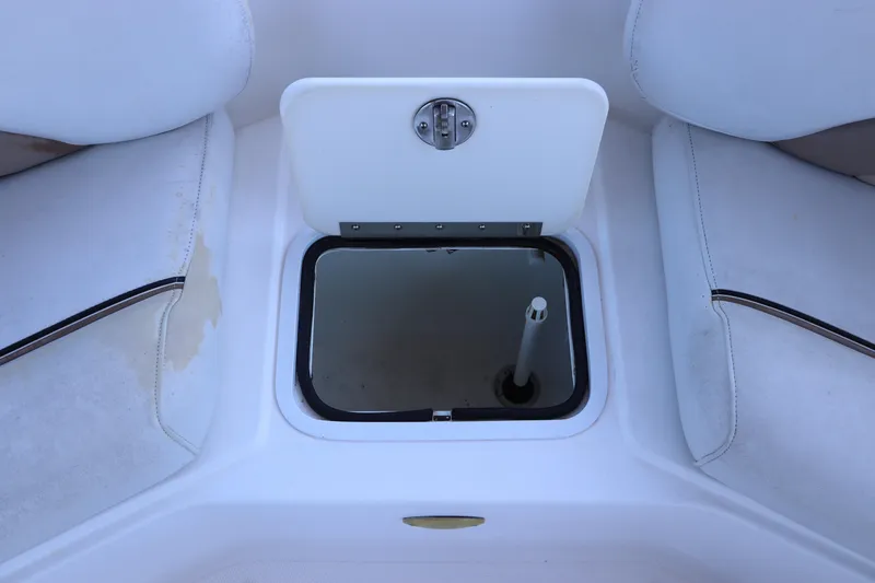 Slide: The Image of 2005 Hurricane FunDeck GS 201 OB boat storage compartment with white cushioned seating. - 15