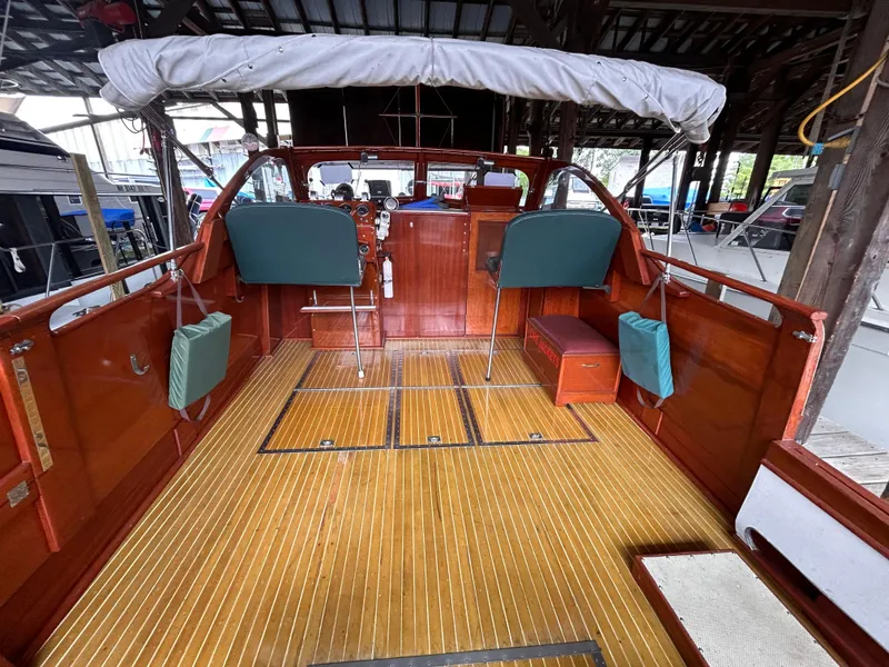 Slide: The Image of 1954 Chris-Craft Commander 336 Express Cruiser with wooden deck and green seating in a boathouse. - 22