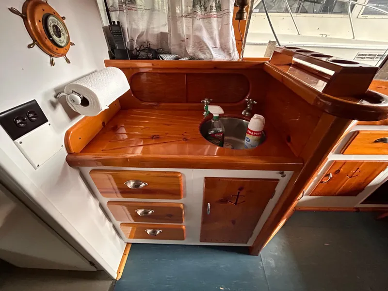 Slide: The Image of 1954 Chris-Craft Commander 336 Express Cruiser interior with wooden cabinetry and small sink. - 44