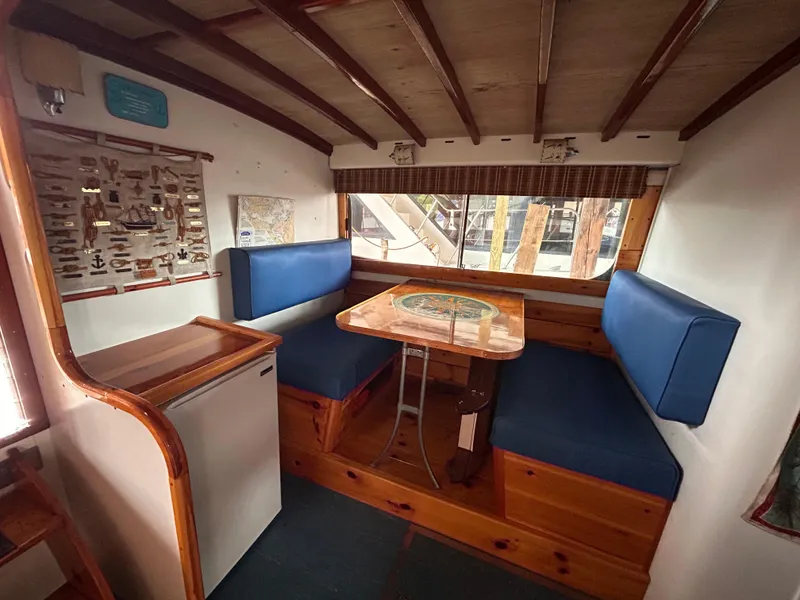 Slide: The Image of 1954 Chris-Craft Commander 336 Express Cruiser interior with blue seating and wooden table. - 46