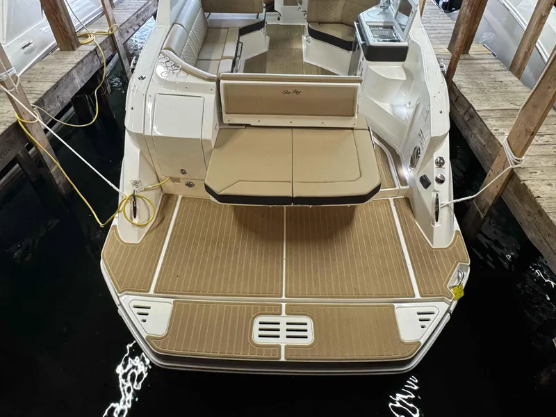 Slide: The Image of 2024 Sea Ray 320DA boat with spacious swim platform and seating in a docked setting. - 13
