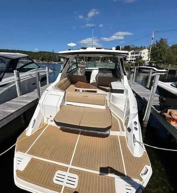 Slide: The Image of 2024 Sea Ray 320DA luxury boat docked, featuring spacious seating and sleek design. - 14