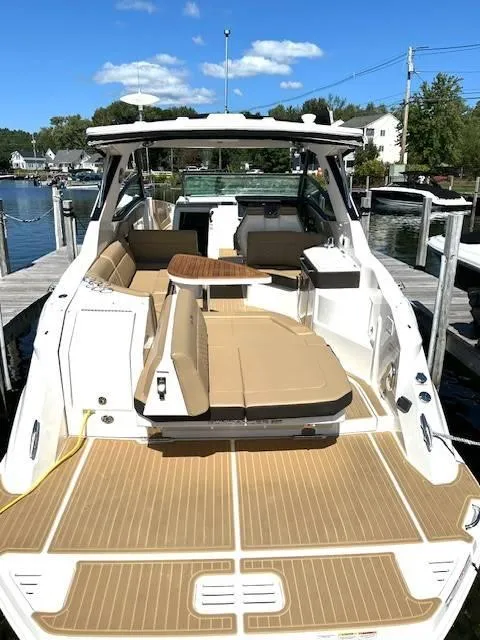 Slide: The Image of 2024 Sea Ray 320DA boat with spacious deck and seating at a marina. - 15